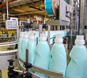 Photo of blue detergent-filled bottles lined up on the production line of a filling machine